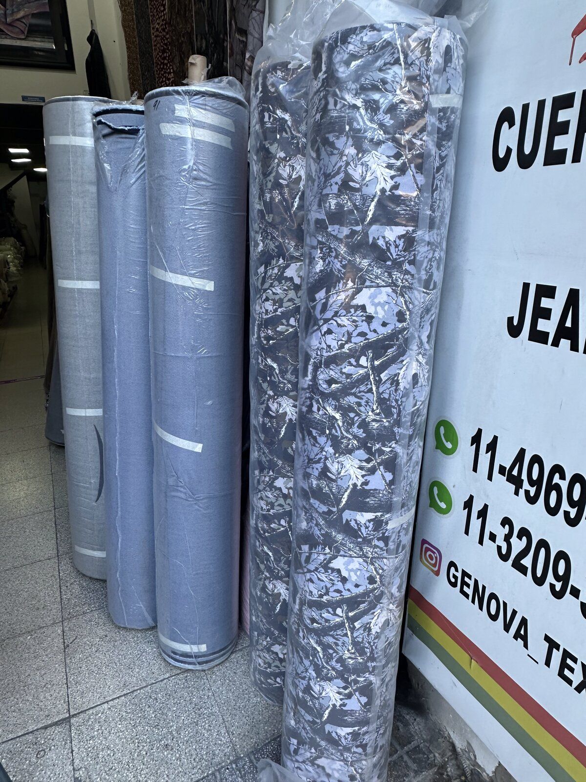 Frente del local Génova Textil en Flores con rollos de jean y estampados